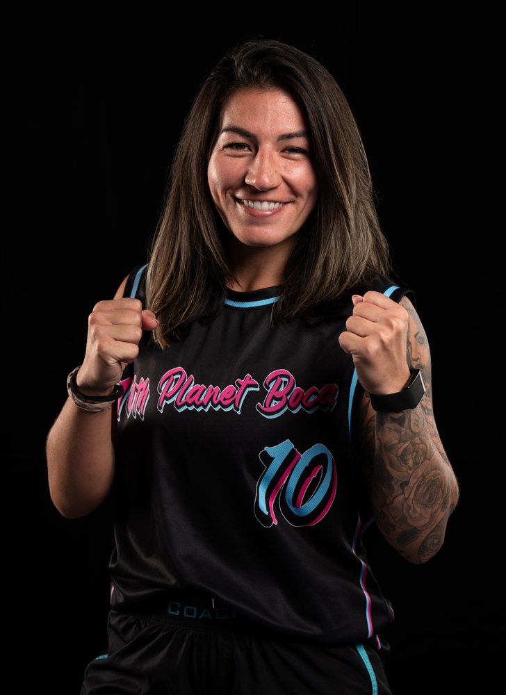 Studio portrait of a smiling coach with her hands raised