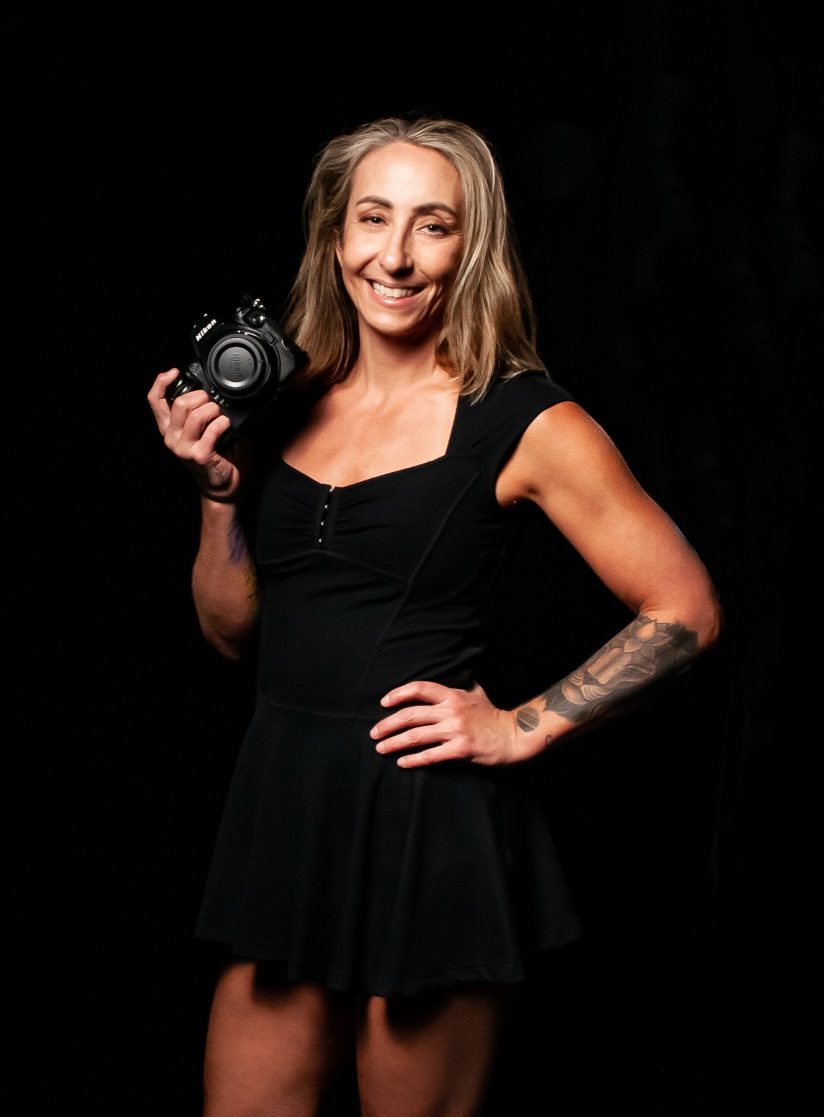 Heather Jo Clark holding her camera, photographer behind Black Belt Portraits