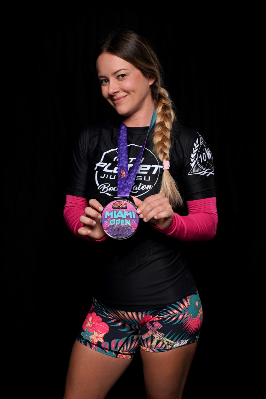 Chrissy holding her ADCC Miami Open medal in a studio portrait