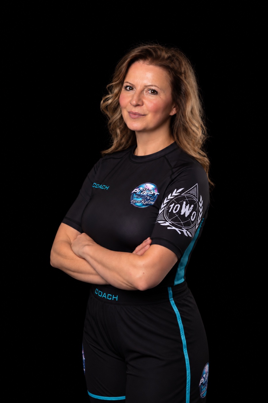 Studio portrait of a coach with folded arms in 10th Planet Boca Raton training gear