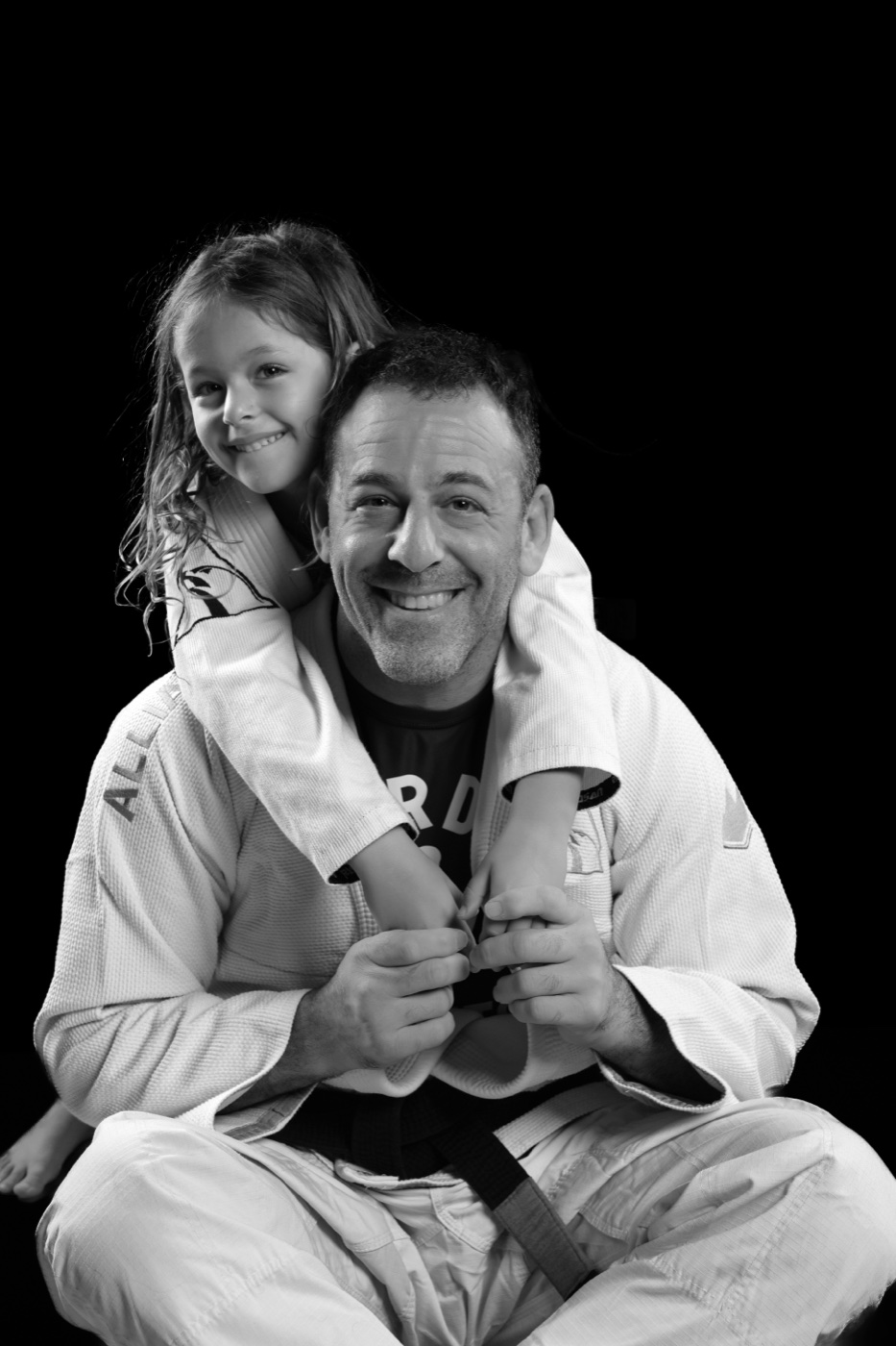 Black-and-white portrait of a daughter on her father’s shoulders