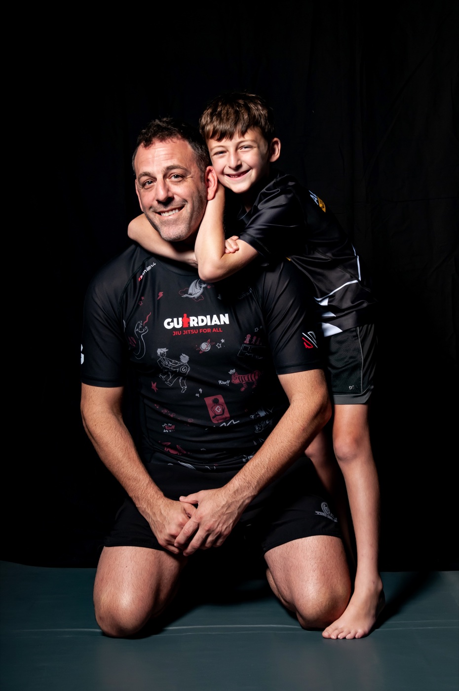 A father and son smiling together during their studio session