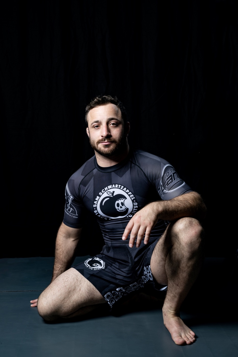 Seated martial arts portrait against a black backdrop